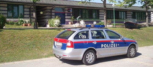Streifenwagen der Polizei. Im Hintergrund die Dienststelle.