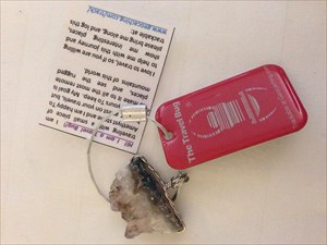 Red travel bug tag with a piece of amythest stone