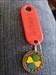 555 Caches Red key tag attached to &quot;Geocaching makes you happy&quot; coin with clover design