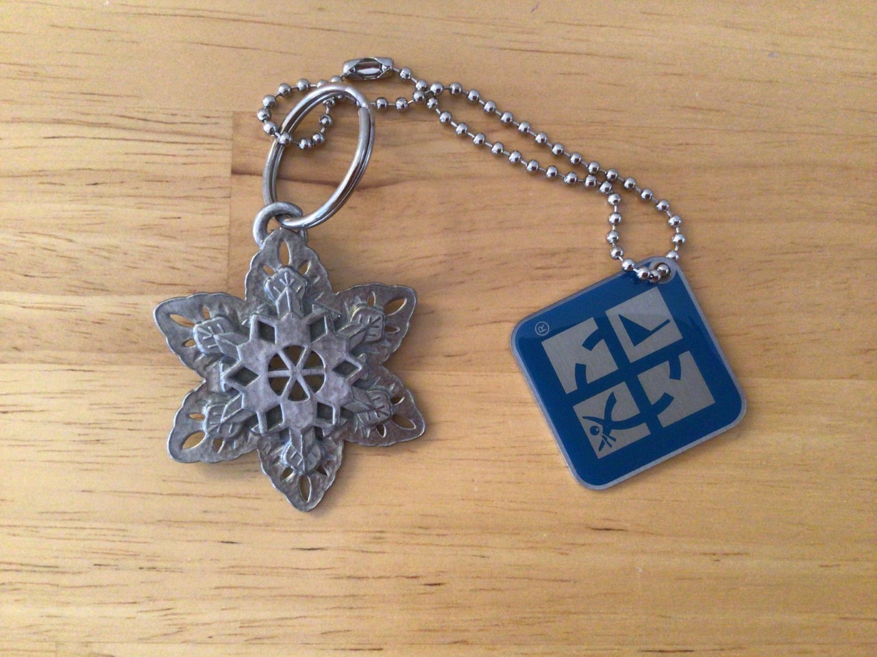 Geocaching blue logo travel tag with pewter snowflake key chain hitch hiker