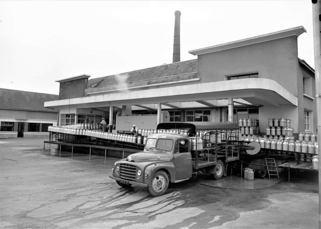 photo noir et blanc de la laiterie avec camion, chaine de bidon de lait et ouvriers (non daté)
